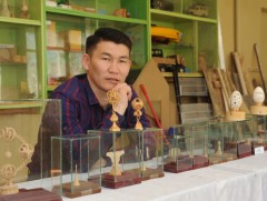 М.Пүрэвжав шүдний чигчлүүрийн дайтай модон дээр сийлбэр хийж байна